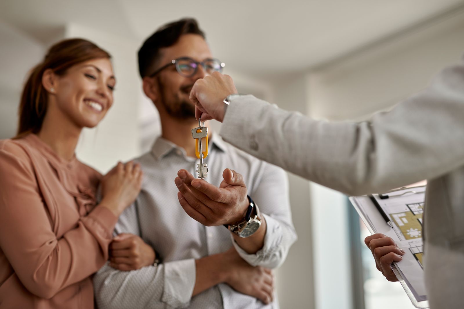 Real estate agent handing house keys to a happy California couple